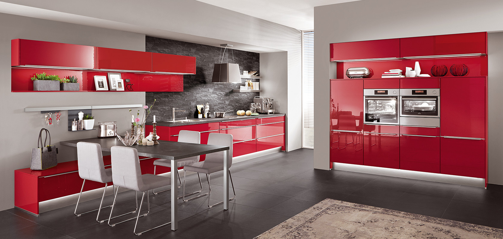 This kitchen in Red high gloss lacquered laminate is a clear affirmation of colour and a real eye-catcher in every flat. Indeed, uprights and top shelves were combined in the same shade and made from the same material. The only accents necessary are the beautifully harmonised stainless steel coloured bar handles and the worktop in Black granite décor.